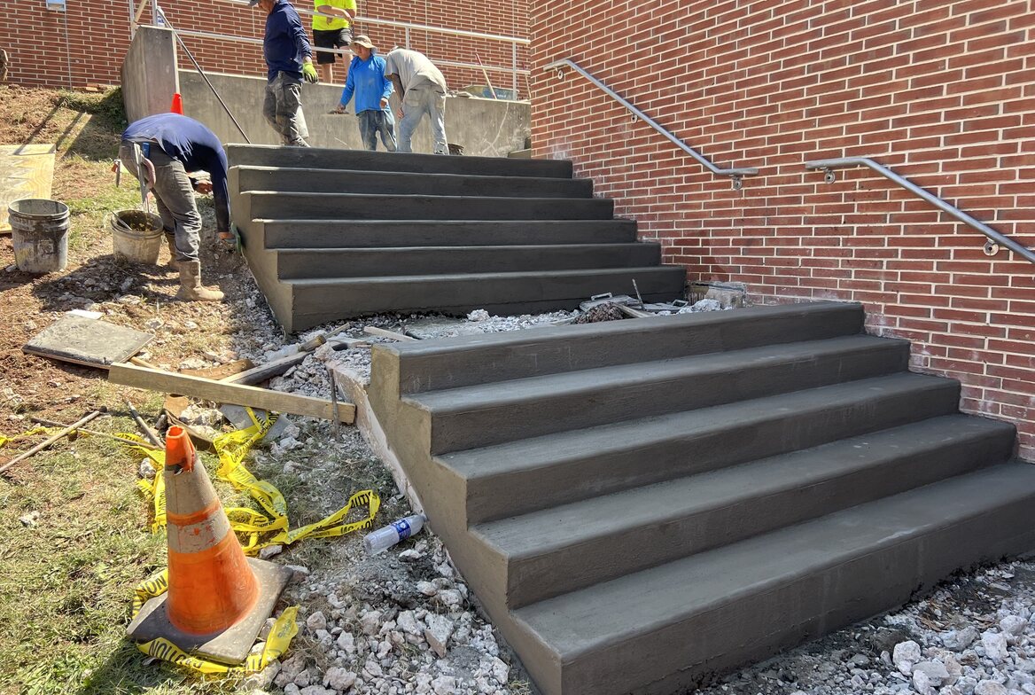 Trainor crew finishing a tiered concrete staircase on a commercial job